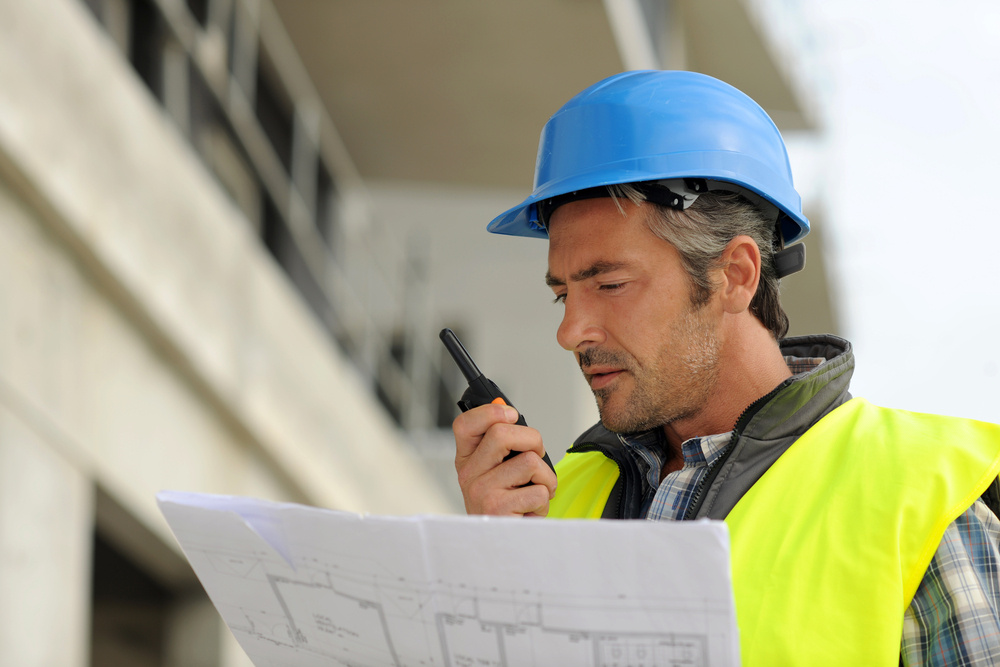 Portrait of construction manager using walkie-talkie Portrait of construction manager using walkie-talkie