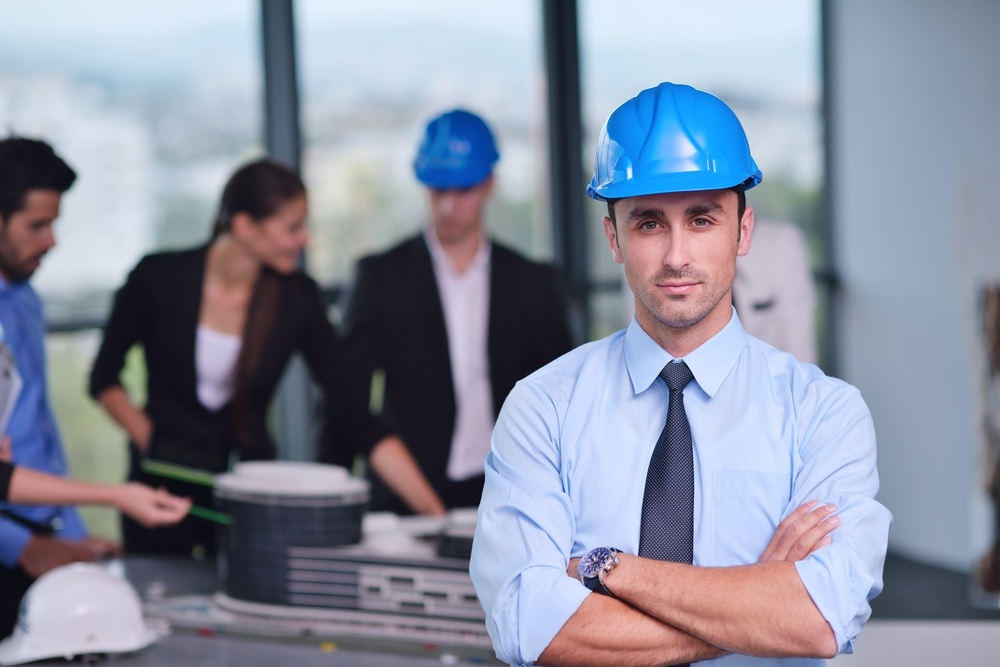 business people group on meeting and presentation  in bright modern office with construction engineer architect and worker looking building model and blueprint planbleprint plans